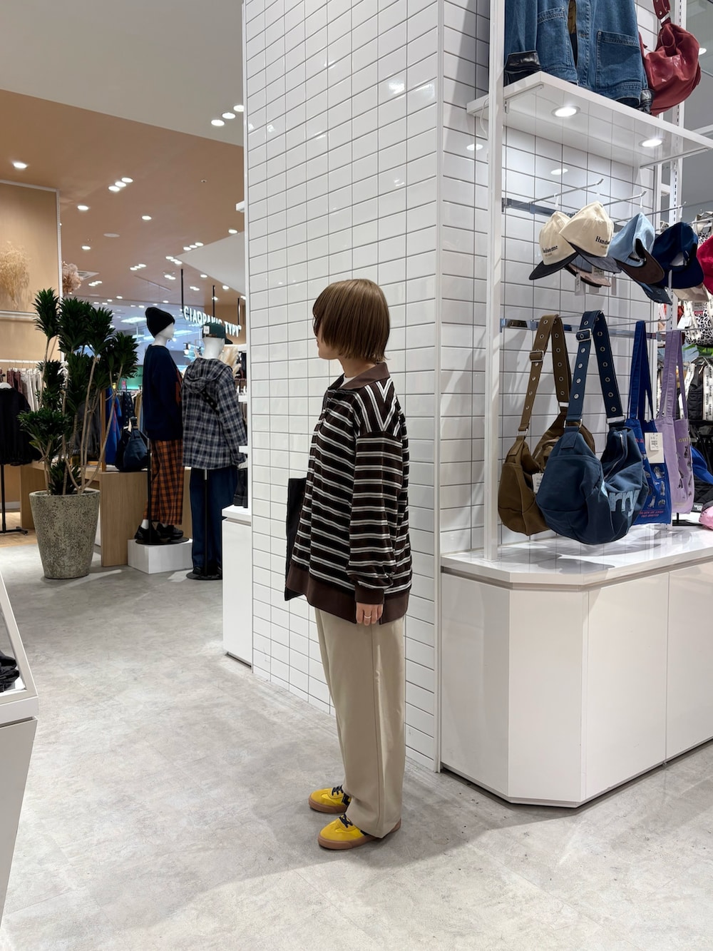 ブラウン系のTシャツ/カットソー、ベージュ系のスラックス、ブラック系のトートバッグを着用したレディースの秋コーディネートの4枚目の写真