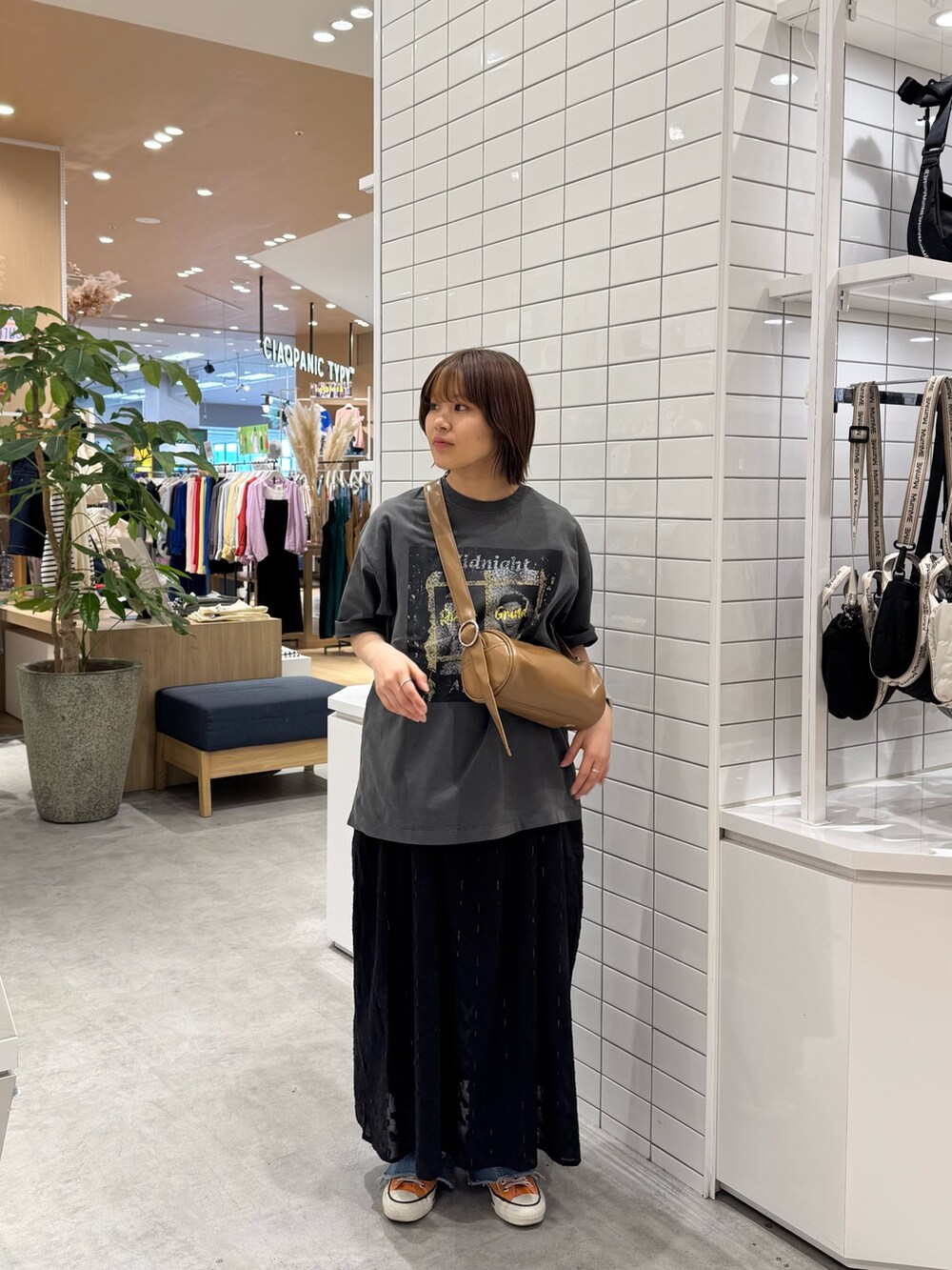 ブラック系のTシャツ/カットソー、ブラック系のワンピース、ブルー系のデニムパンツを着用したレディースの春コーディネートの2枚目の写真