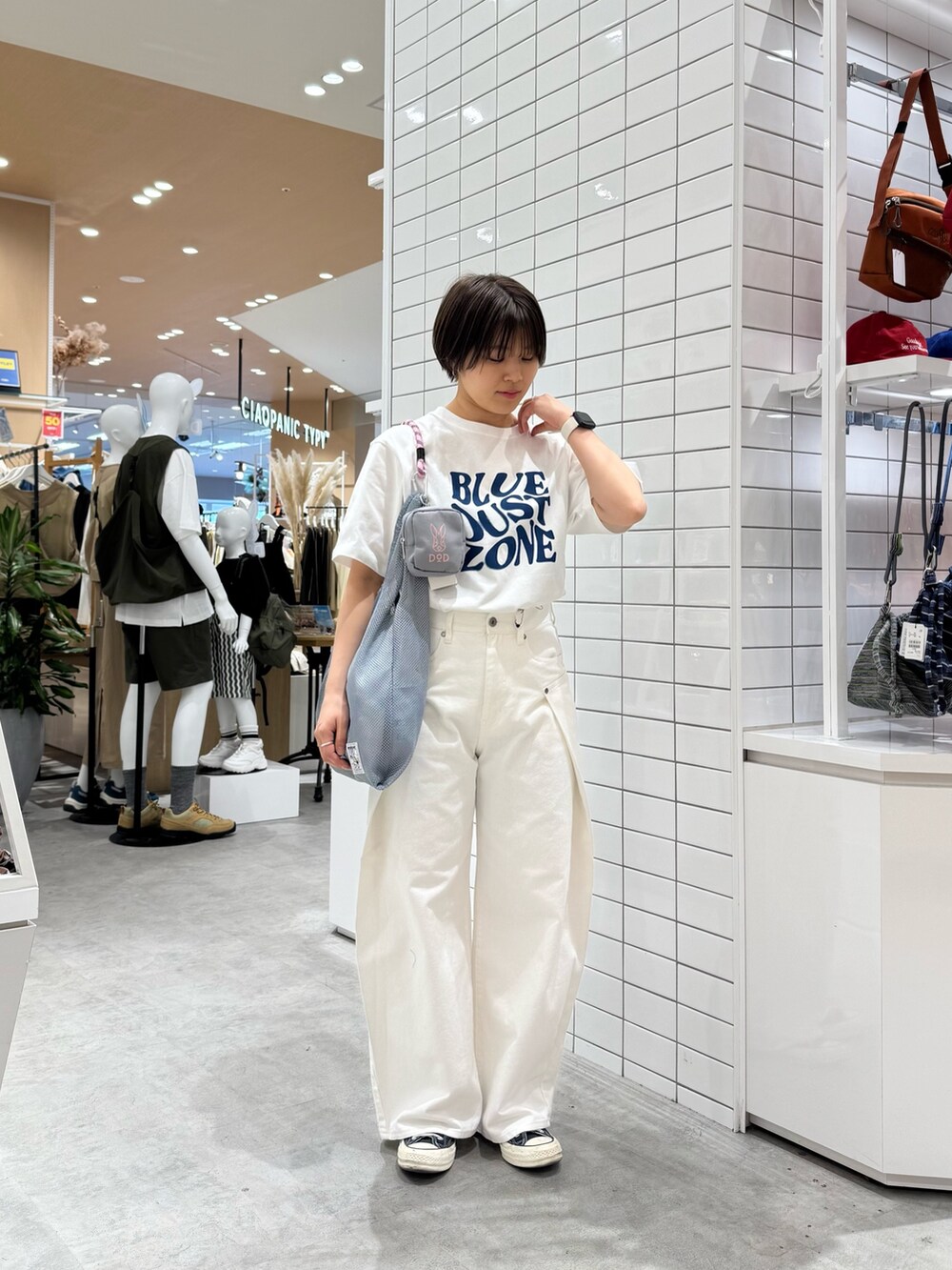 ホワイト系のTシャツ/カットソー、ホワイト系のデニムパンツ、グレー系のトートバッグを着用したレディースの春コーディネートの2枚目の写真