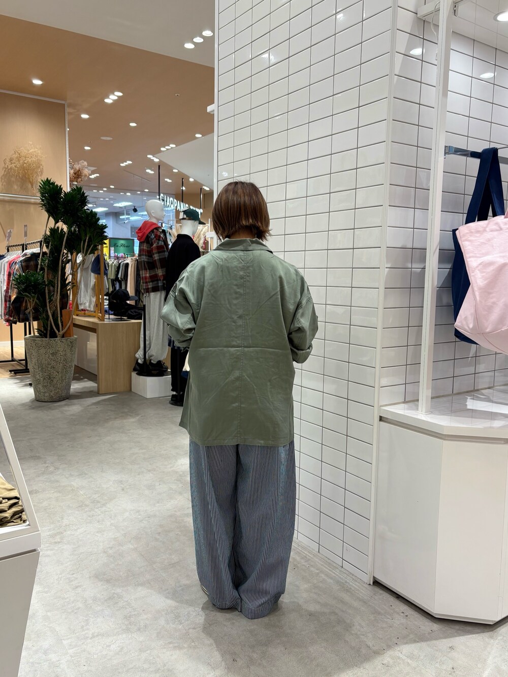 ブルー系のデニムパンツ、ホワイト系のTシャツ/カットソー、グリーン系のシャツ/ブラウスを着用したレディースの秋コーディネートの4枚目の写真