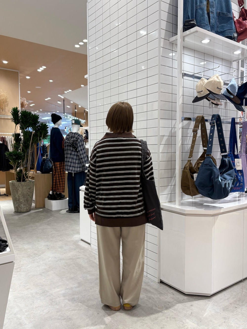 ブラウン系のTシャツ/カットソー、ベージュ系のスラックス、ブラック系のトートバッグを着用したレディースの秋コーディネートの5枚目の写真