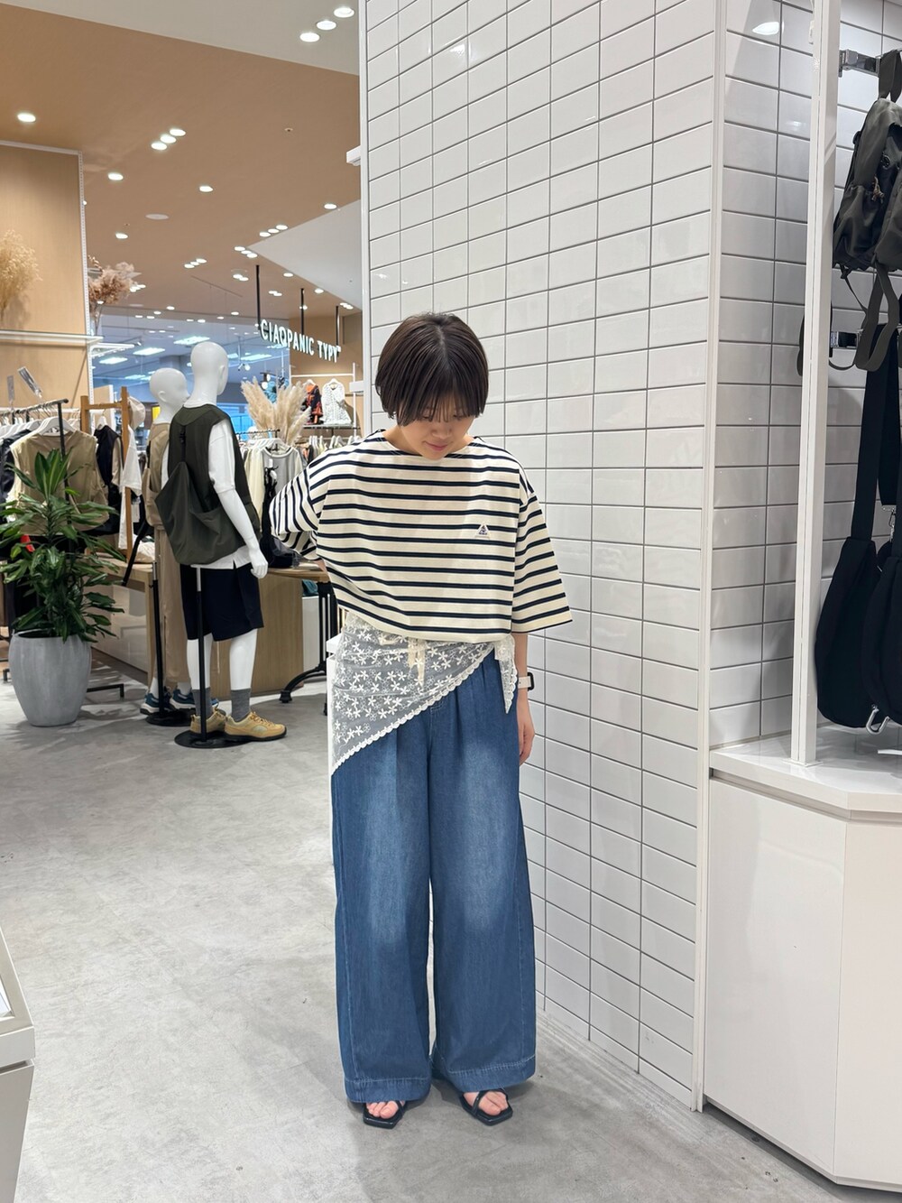 ホワイト系のTシャツ/カットソー、ブルー系のデニムパンツ、ブラック系のサンダルを着用したレディースの夏コーディネートの3枚目の写真