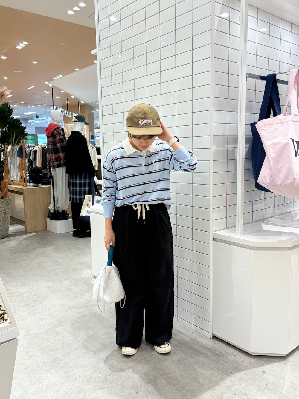 ブルー系のニット/セーター、ブラック系のデニムパンツ、グレー系のハンドバッグを着用したレディースの秋コーディネートの3枚目の写真