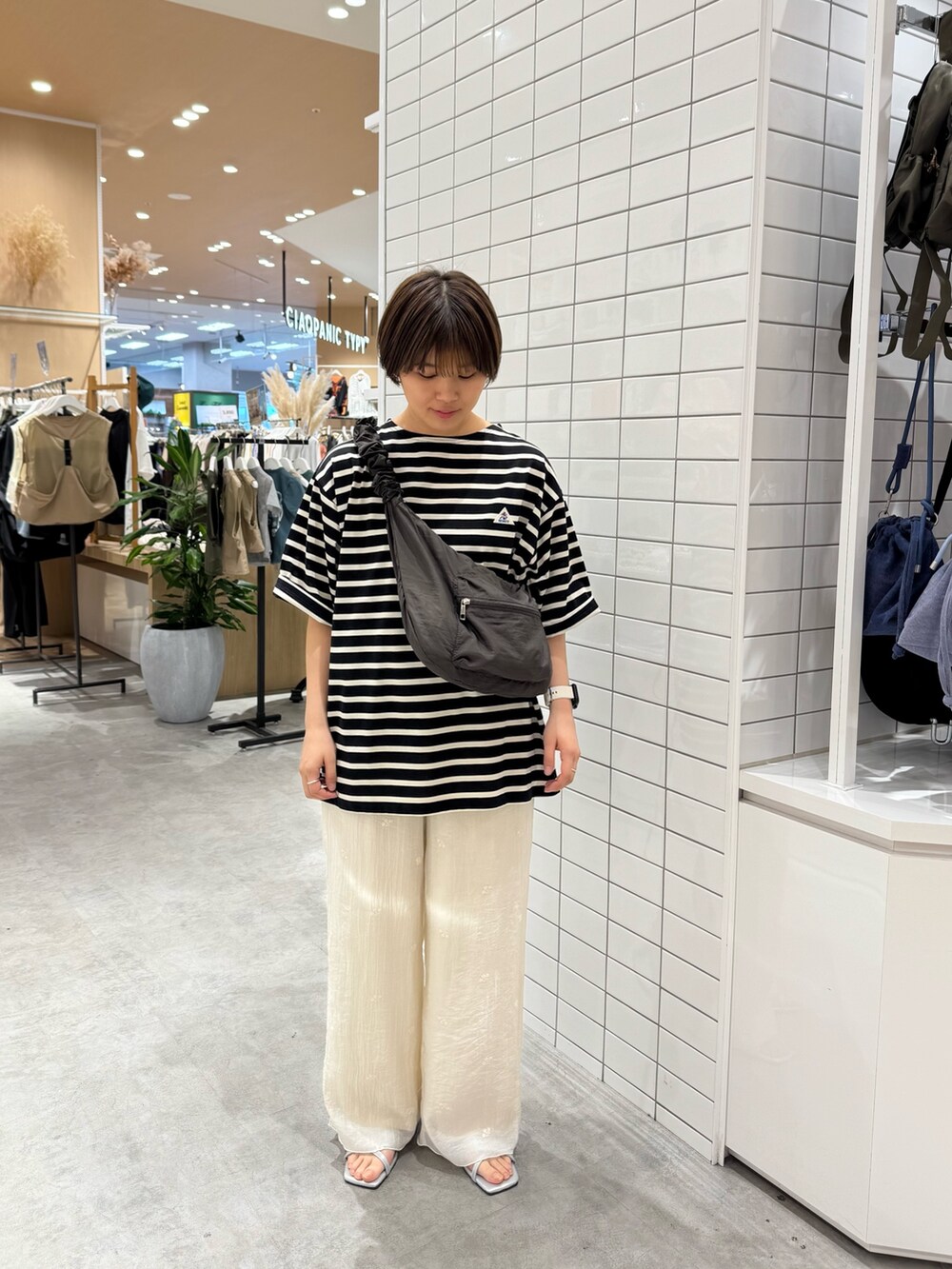 グレー系のトートバッグ、ブラック系のTシャツ/カットソー、ホワイト系のその他パンツを着用したレディースの夏コーディネートの2枚目の写真