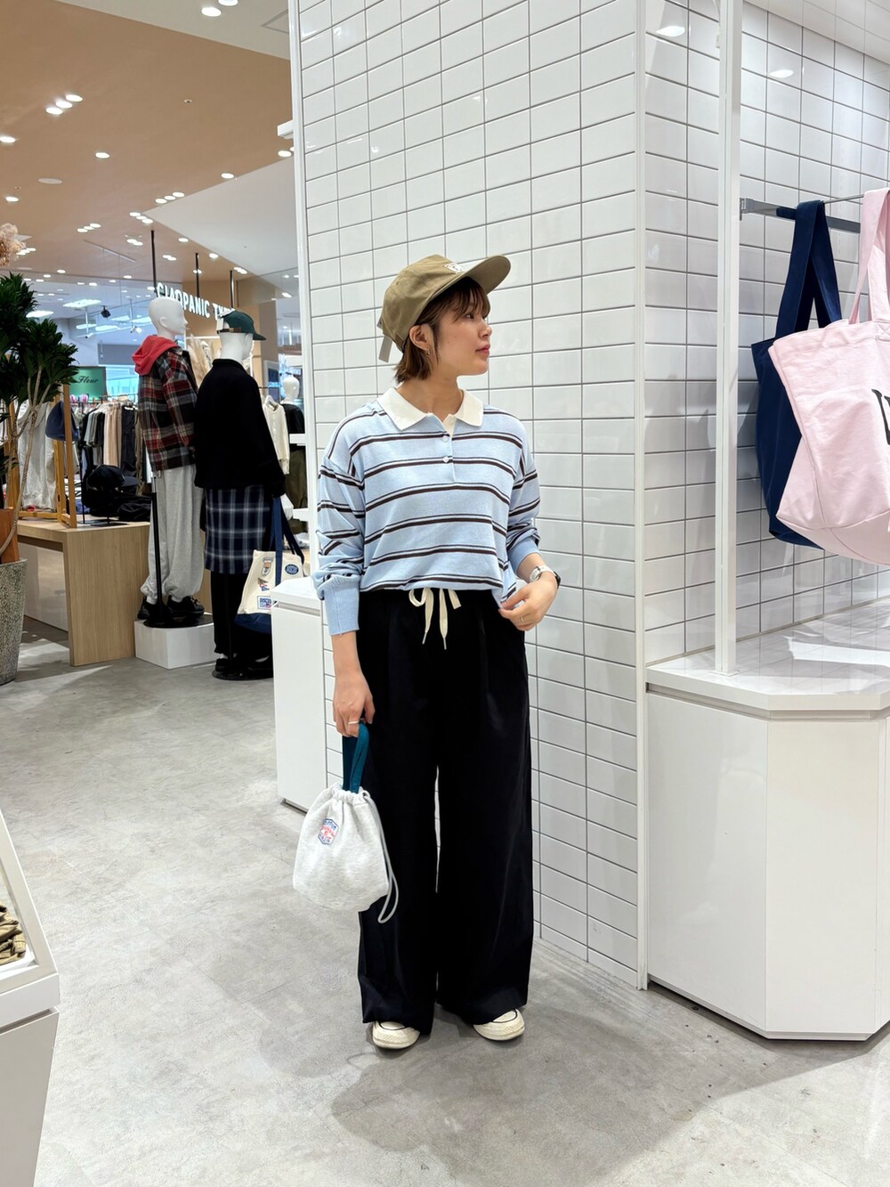 ブルー系のニット/セーター、ブラック系のデニムパンツ、グレー系のハンドバッグを着用したレディースの秋コーディネートの4枚目の写真