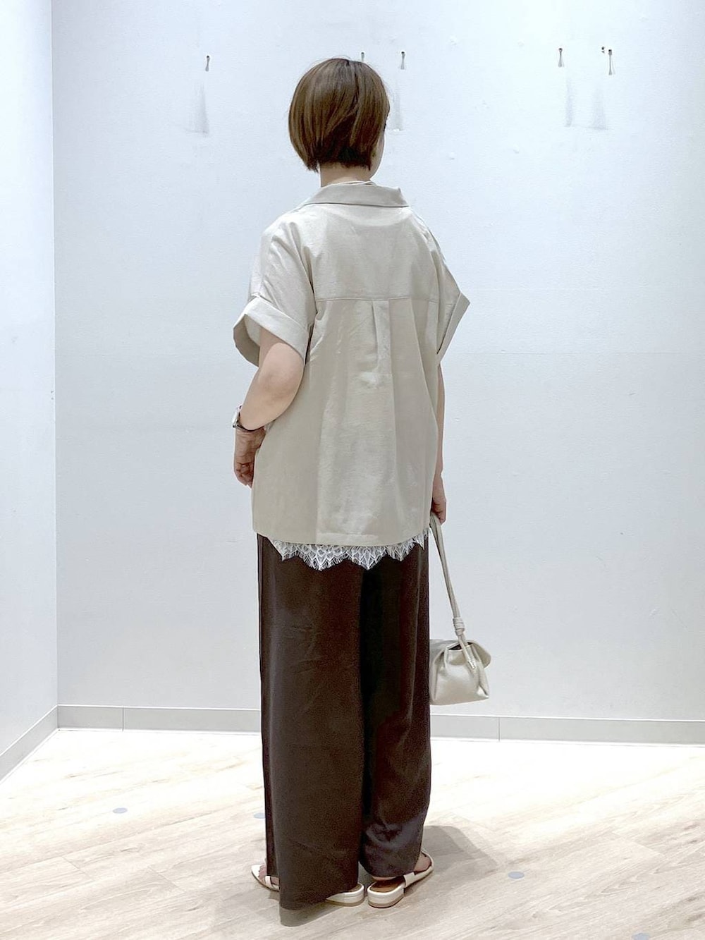 ベージュ系のショルダーバッグ、ブラウン系のその他パンツ、ベージュ系のシャツ/ブラウスを着用したレディースの夏コーディネートの3枚目の写真