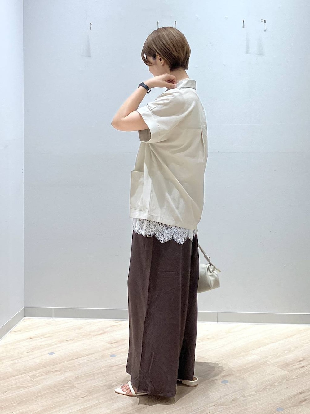 ベージュ系のショルダーバッグ、ブラウン系のその他パンツ、ベージュ系のシャツ/ブラウスを着用したレディースの夏コーディネートの2枚目の写真