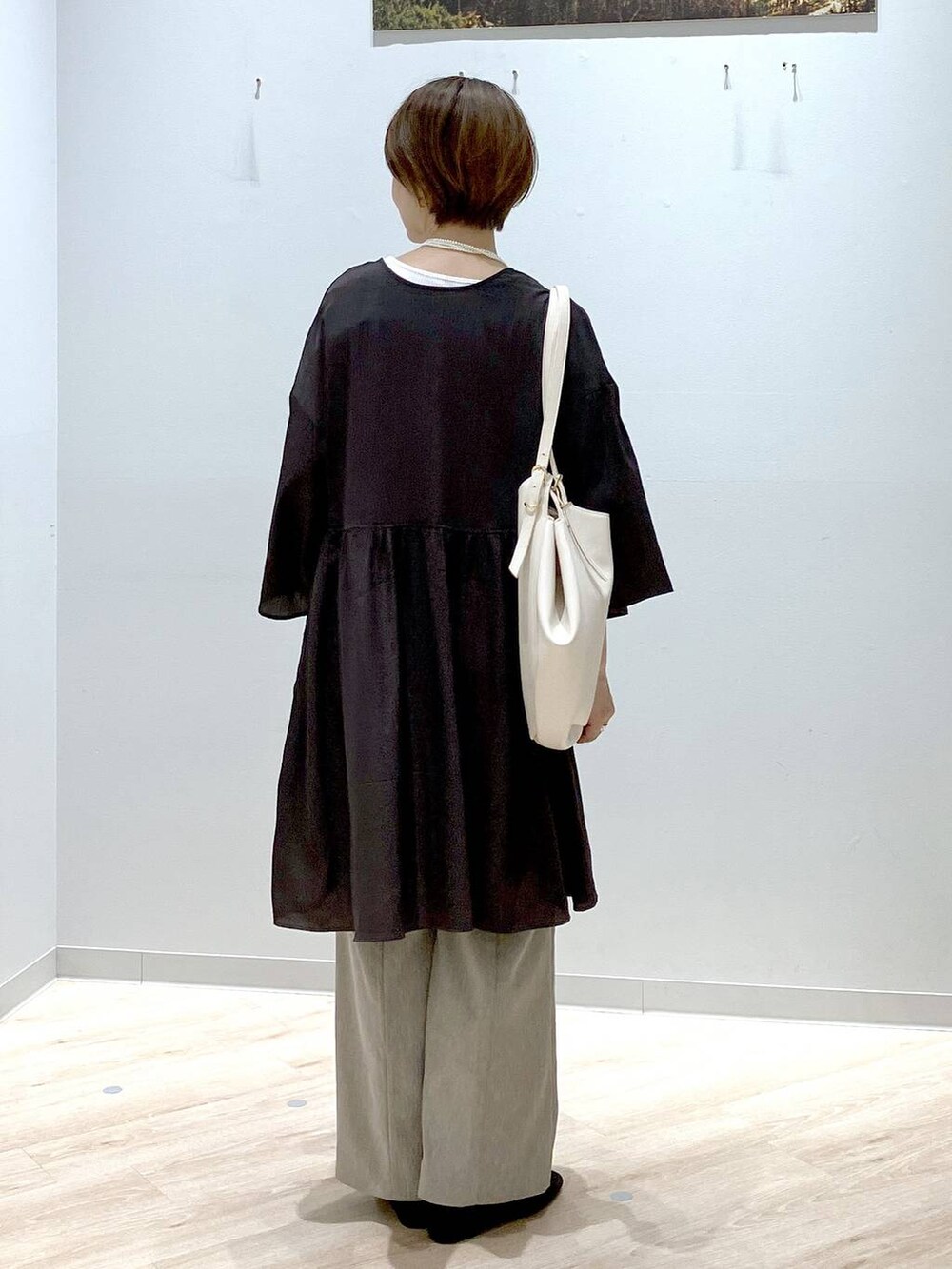 ブラック系のパンプス、ホワイト系のショルダーバッグ、ホワイト系のタンクトップを着用したレディースの秋コーディネートの3枚目の写真