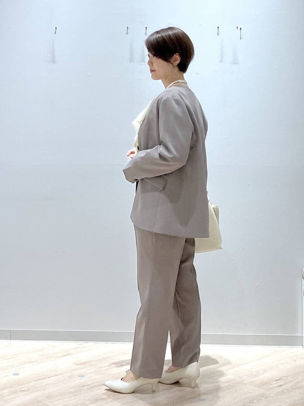 ホワイト系のパンプス、ブラウン系のその他パンツ、ブラウン系のテーラードジャケットを着用したレディースの春コーディネートの3枚目の写真