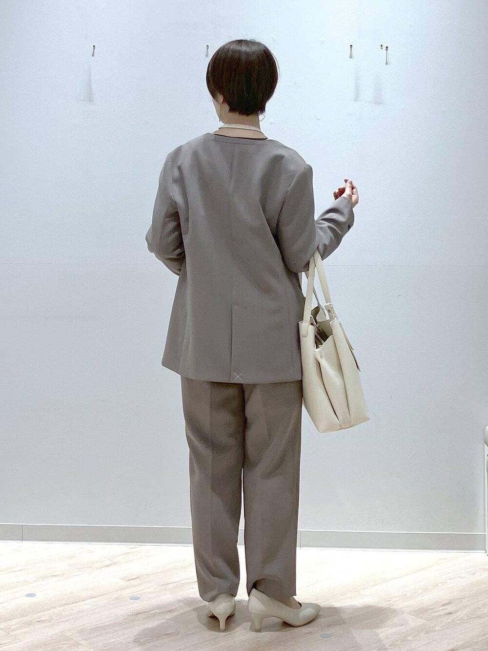 ホワイト系のパンプス、ブラウン系のその他パンツ、ブラウン系のテーラードジャケットを着用したレディースの春コーディネートの4枚目の写真