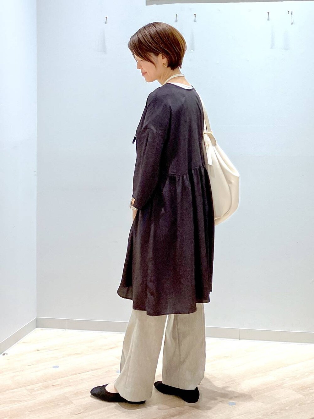 ブラック系のパンプス、ホワイト系のショルダーバッグ、ホワイト系のタンクトップを着用したレディースの秋コーディネートの2枚目の写真