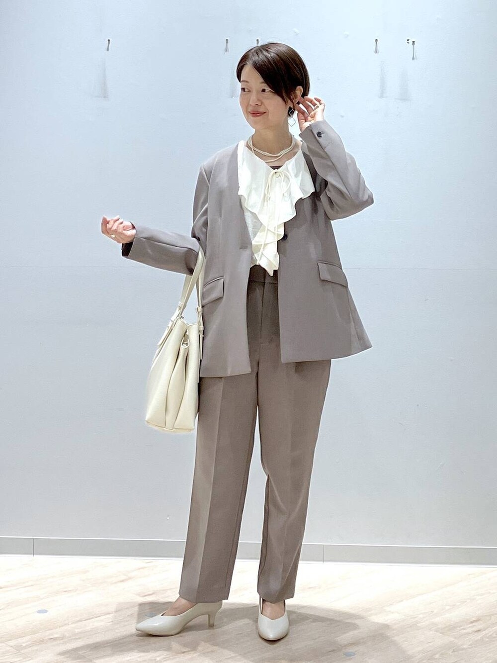 ホワイト系のパンプス、ブラウン系のその他パンツ、ブラウン系のテーラードジャケットを着用したレディースの春コーディネートの2枚目の写真