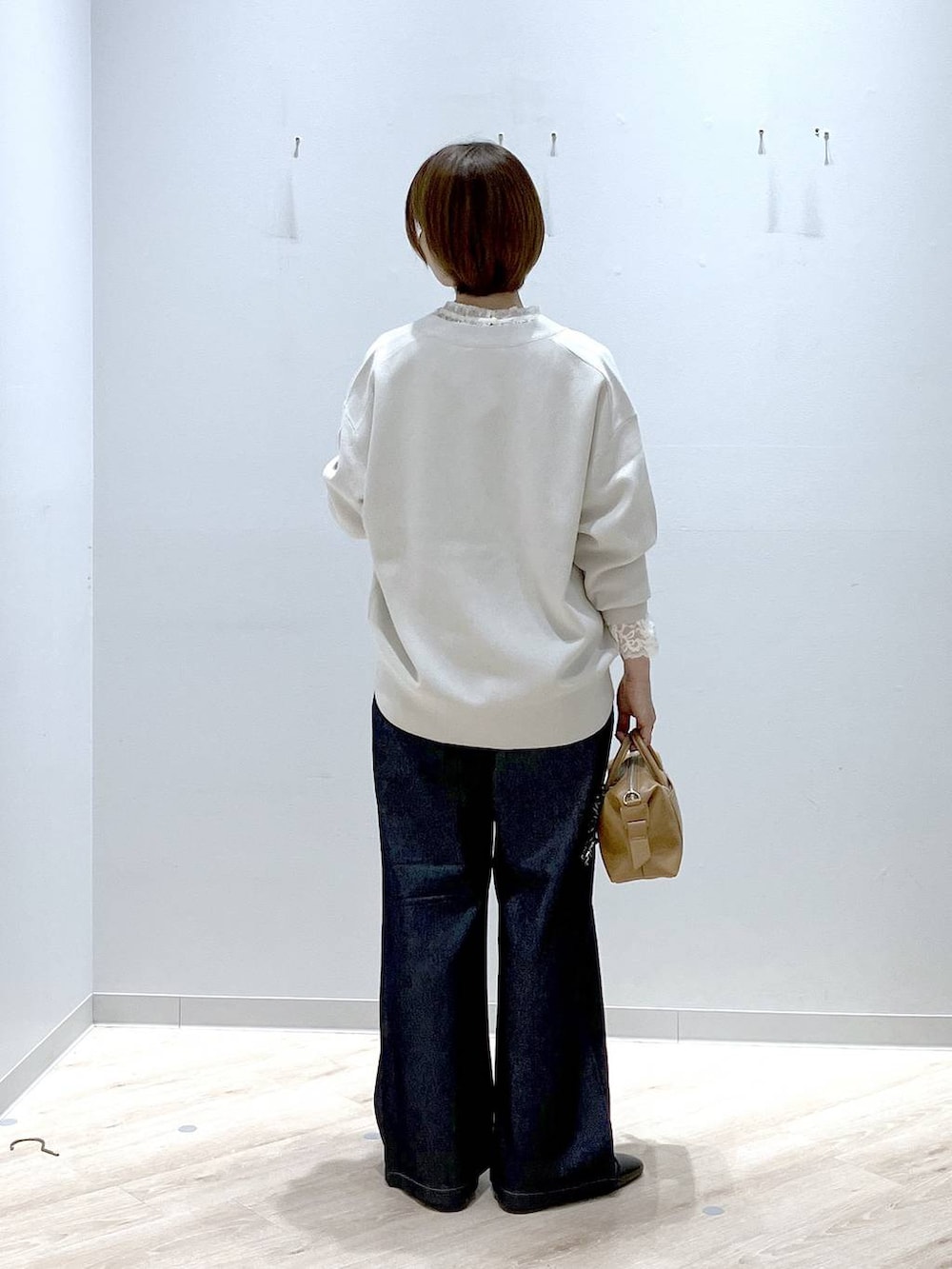 ブラック系のパンプス、ブラウン系のボストンバッグ、ベージュ系のカーディガン/ボレロを着用したレディースの秋コーディネートの3枚目の写真