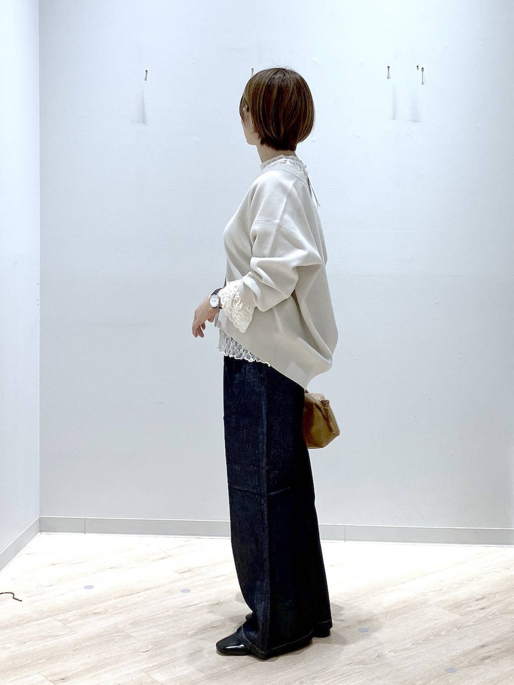 ブラック系のパンプス、ブラウン系のボストンバッグ、ベージュ系のカーディガン/ボレロを着用したレディースの秋コーディネートの2枚目の写真