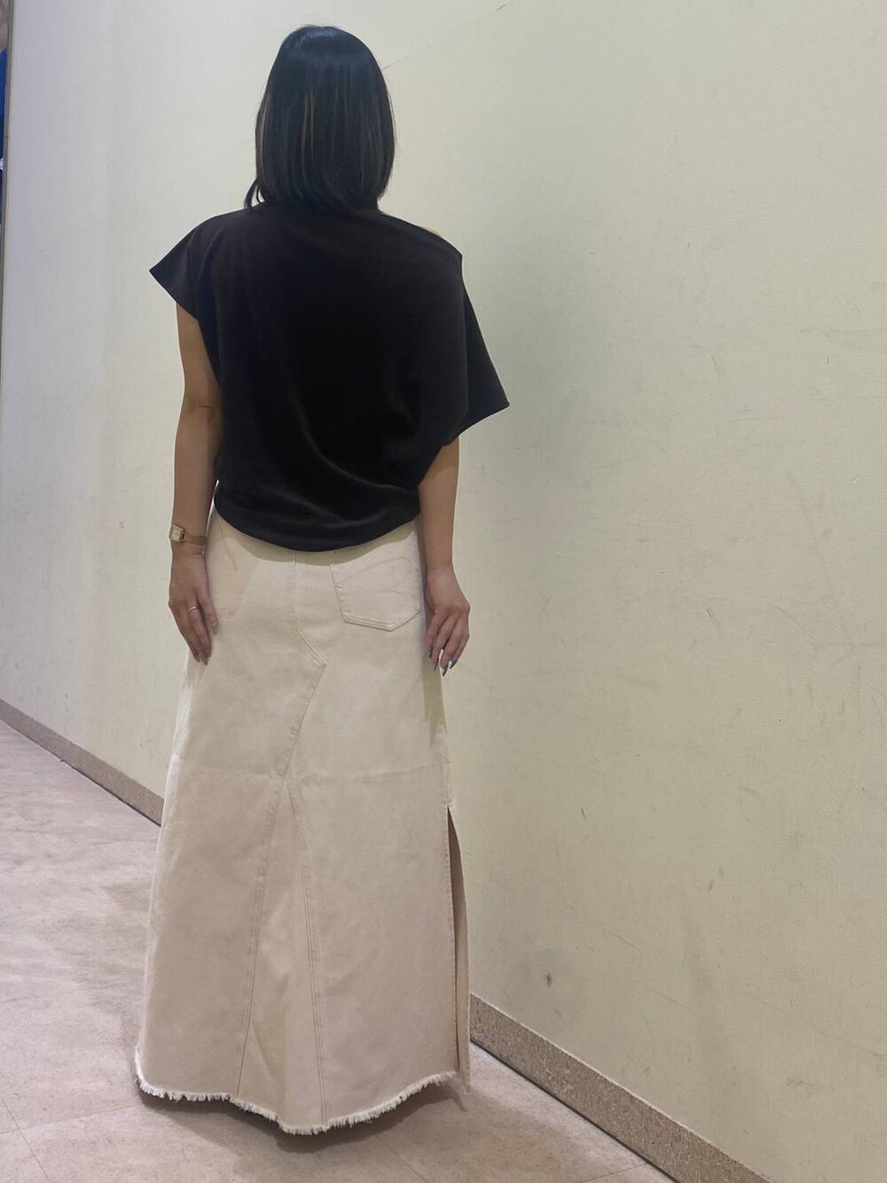 ホワイト系のスカート、ブラック系のサンダル、ブラウン系のTシャツ/カットソーを着用したレディースの夏コーディネートの3枚目の写真
