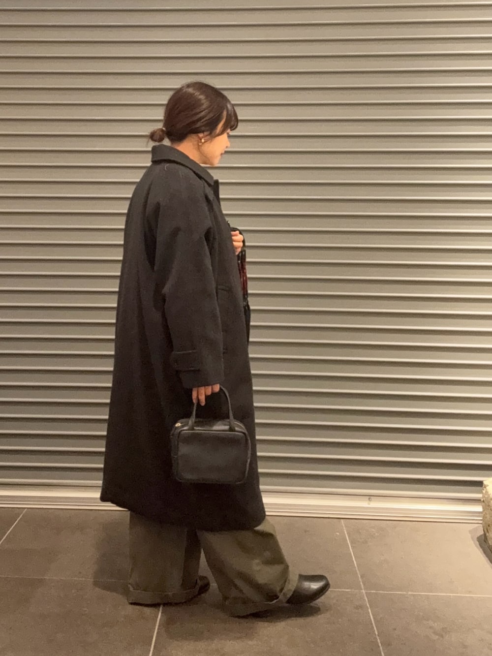 ベージュ系のニット/セーター、グレー系のその他アウター、ブラック系のボストンバッグを着用したレディースの秋コーディネートの2枚目の写真