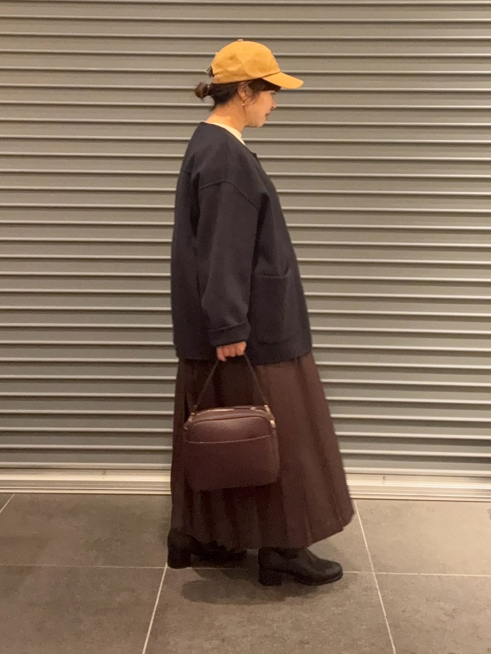 ベージュ系のTシャツ/カットソー、ブラック系のブーツ、ブラウン系のスカートを着用したレディースの秋コーディネートの3枚目の写真
