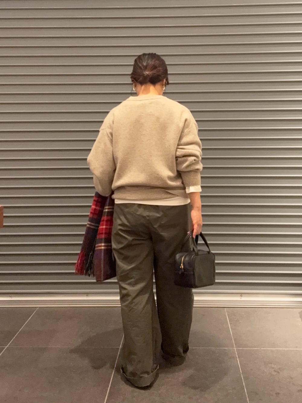 ベージュ系のニット/セーター、グレー系のボストンバッグ、ブラック系のブーツを着用したレディースの秋コーディネートの3枚目の写真