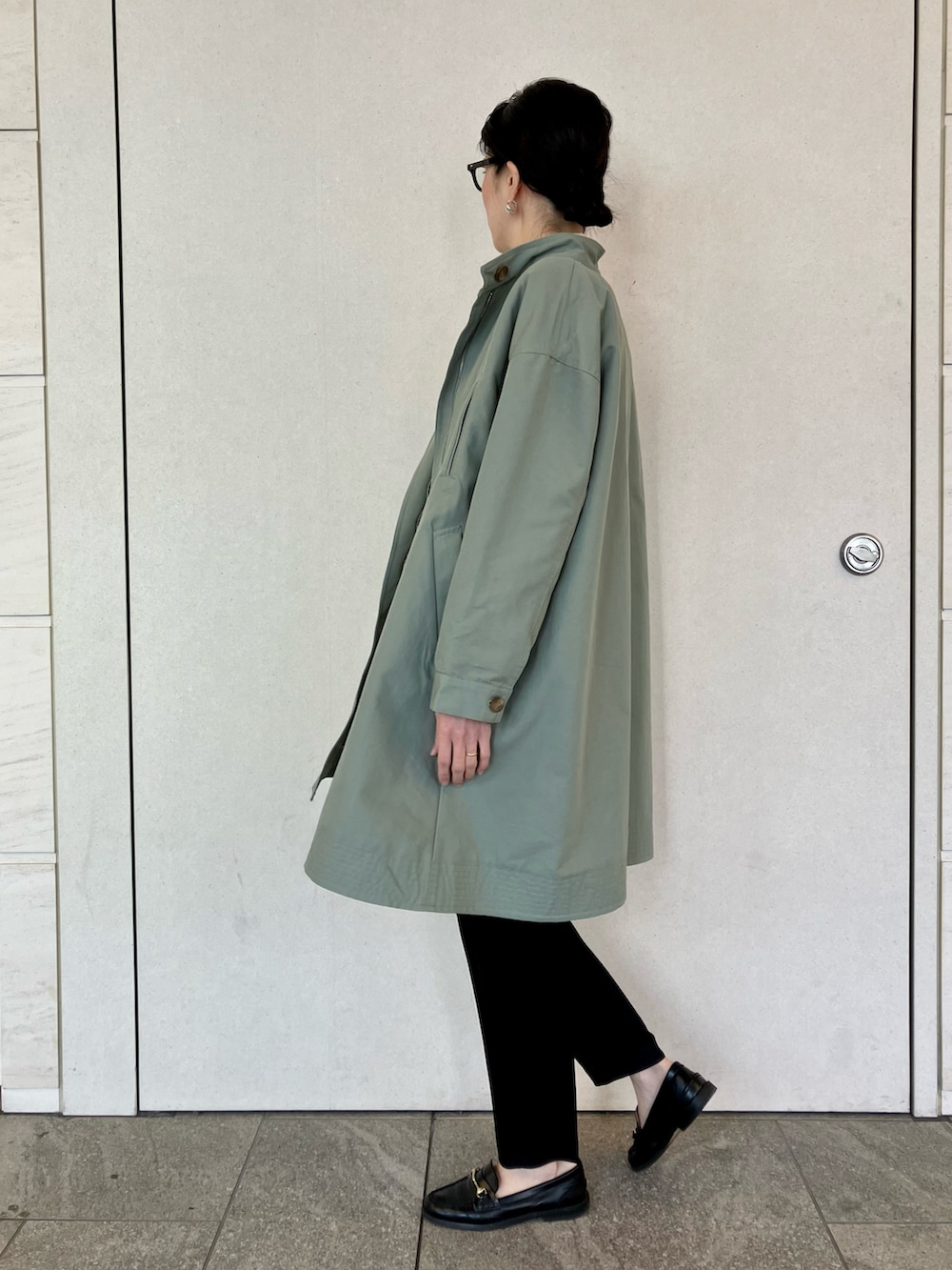 グリーン系のトレンチコート、ホワイト系のシャツ/ブラウス、ブラック系のその他パンツを着用したレディースの春コーディネートの3枚目の写真