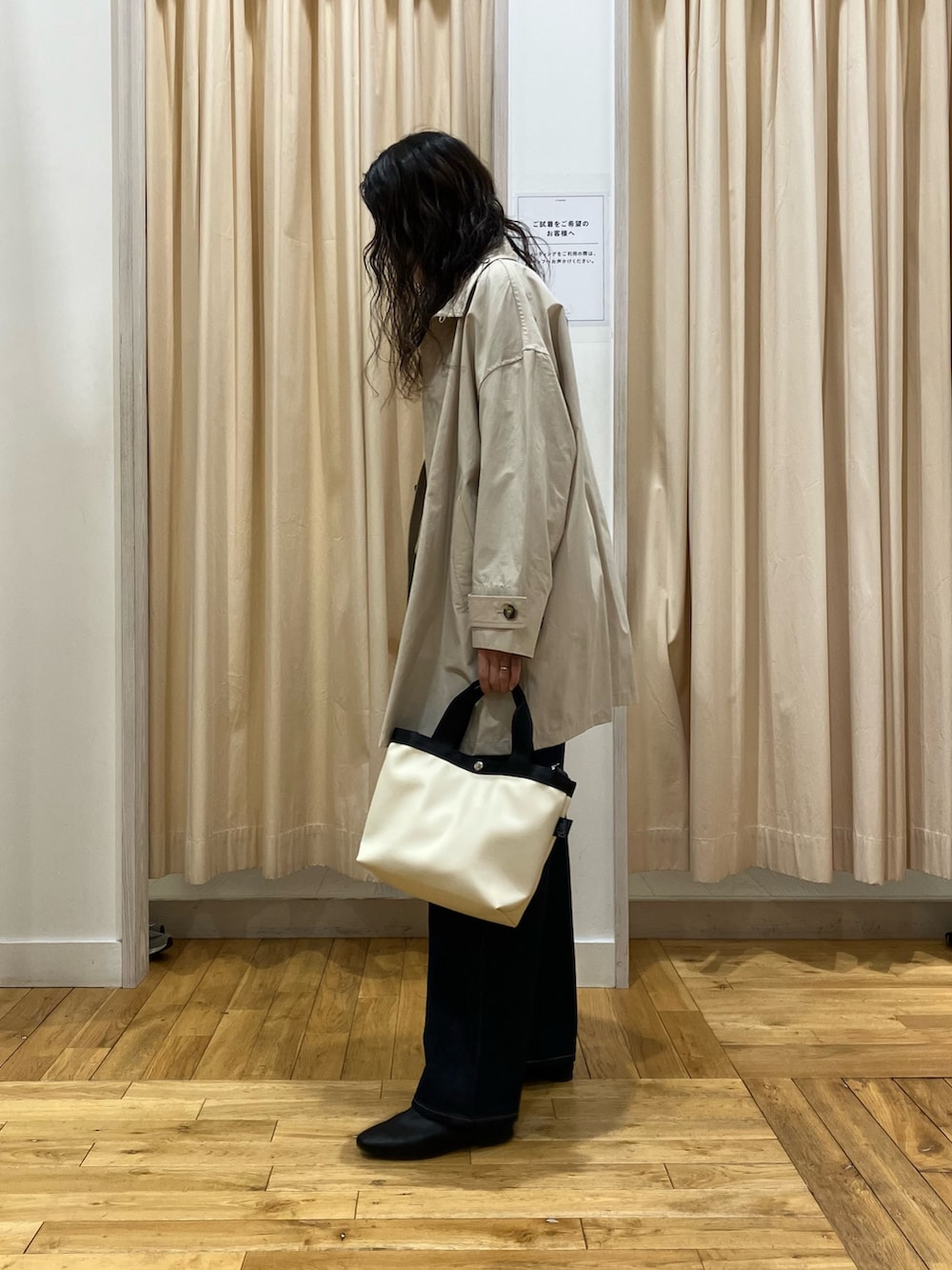 グリーン系のニット/セーター、ベージュ系のステンカラーコート、ブラック系のその他シューズを着用したレディースの春コーディネートの3枚目の写真