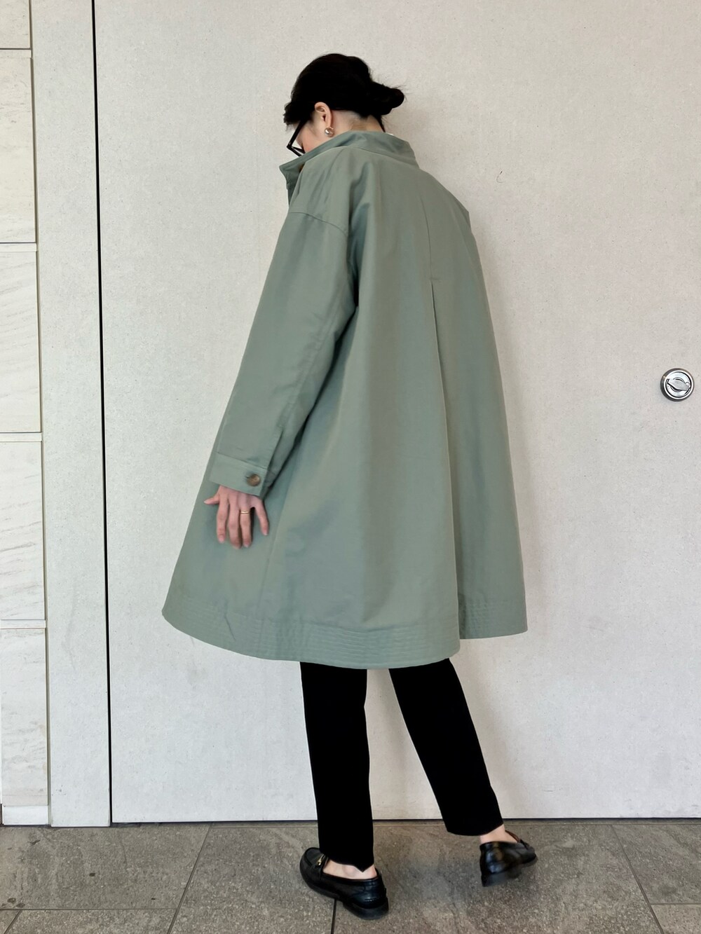 グリーン系のトレンチコート、ホワイト系のシャツ/ブラウス、ブラック系のその他パンツを着用したレディースの春コーディネートの4枚目の写真