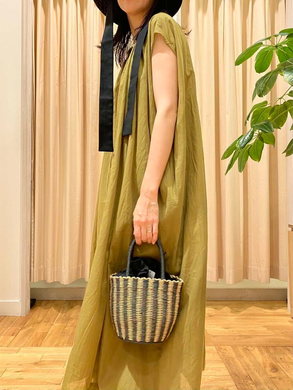 ブラック系のハンドバッグ、ブルー系のその他パンツ、グリーン系のワンピースを着用したレディースの夏コーディネートの6枚目の写真