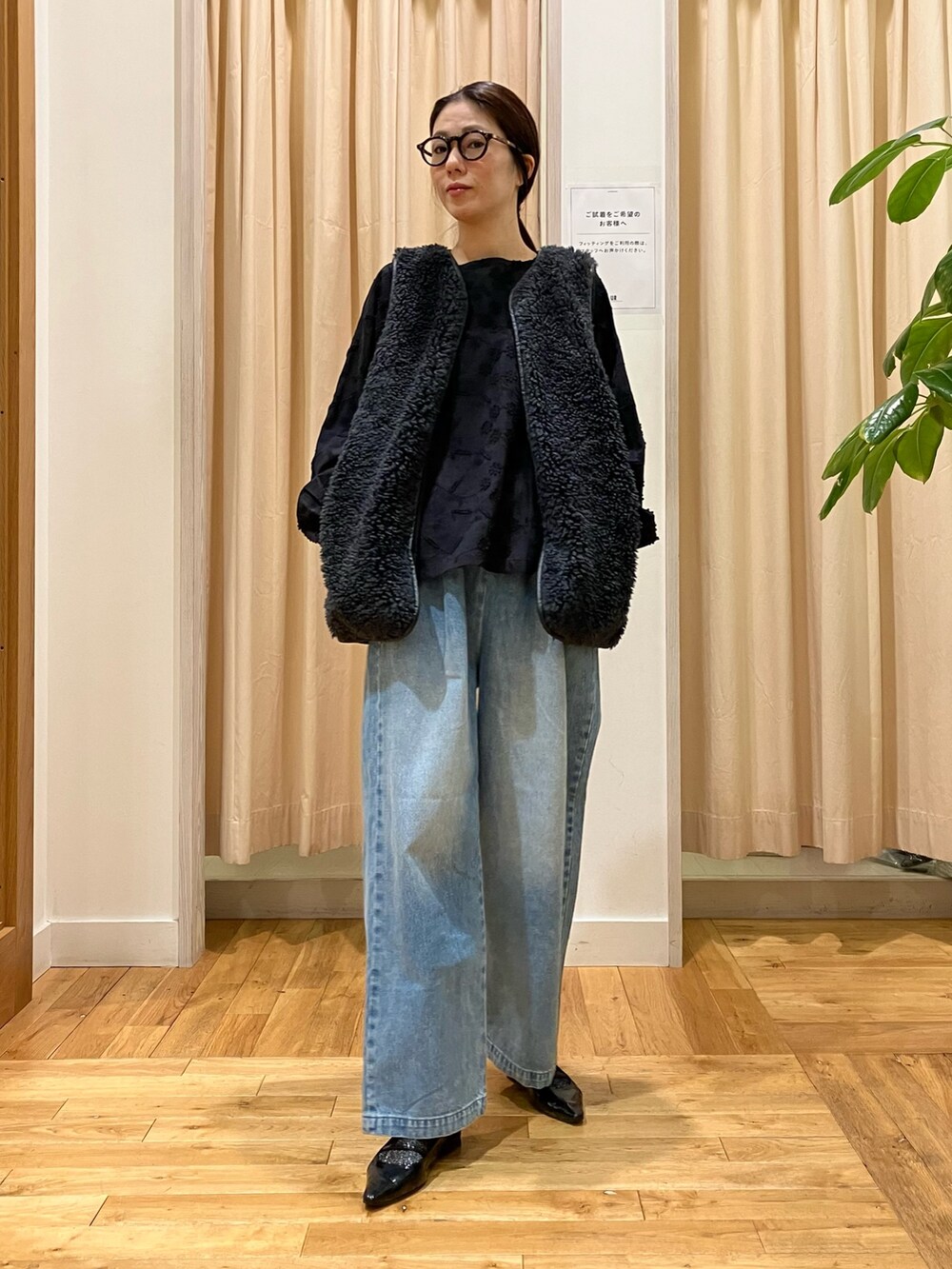 ブラック系のシャツ/ブラウス、グレー系のその他アウター、ブルー系のデニムパンツを着用したレディースの秋コーディネートの2枚目の写真