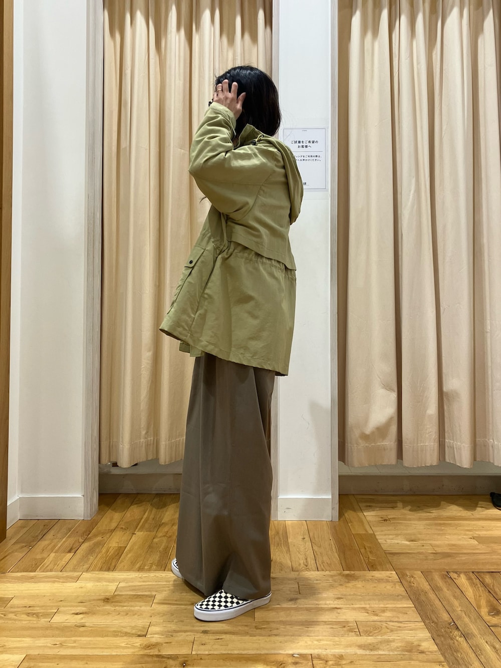 ホワイト系のニット/セーター、グリーン系のマウンテンパーカー、グレー系のその他パンツを着用したレディースの春コーディネートの3枚目の写真