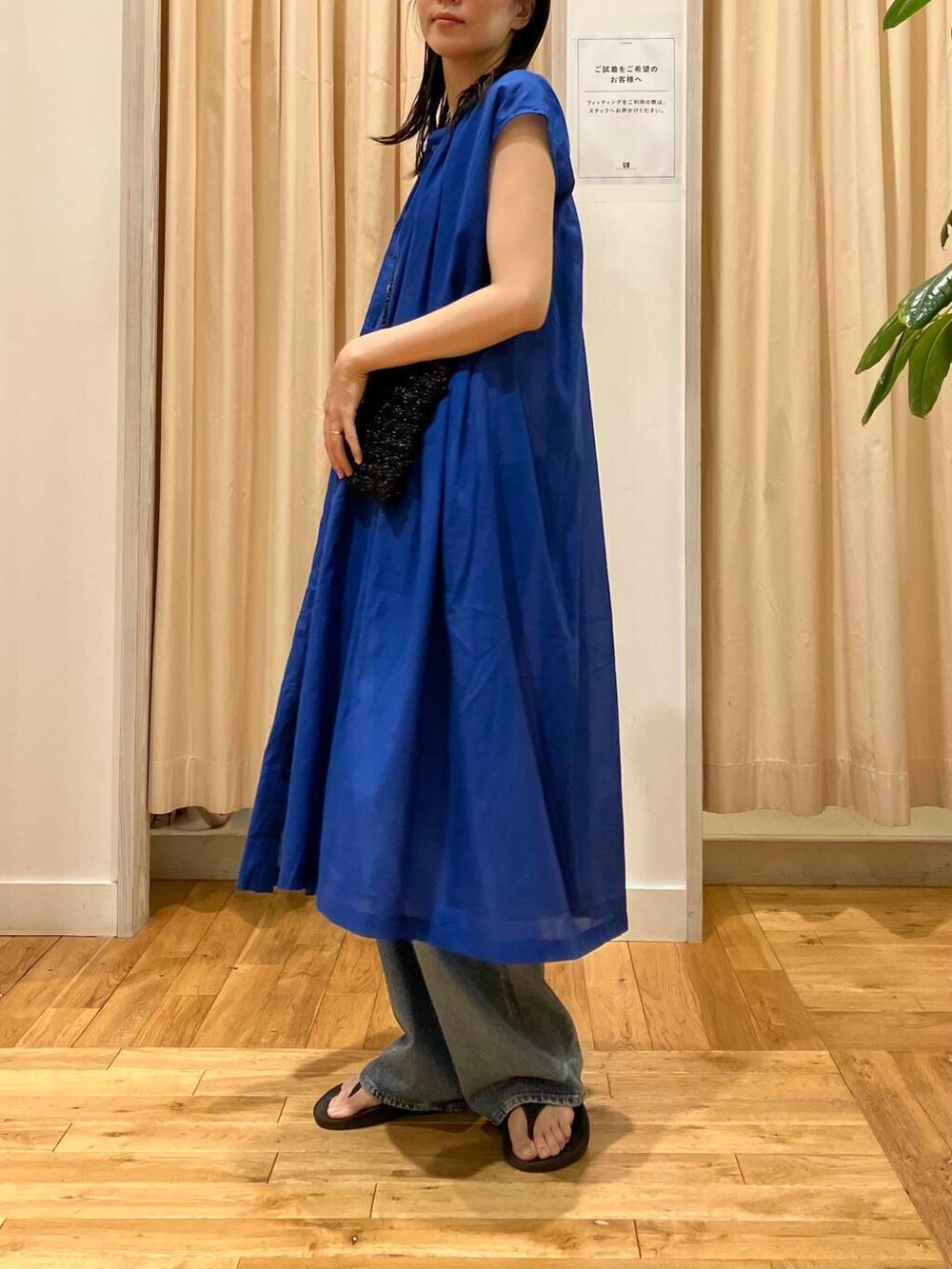 ブルー系のデニムパンツ、ブラック系のサンダル、ホワイト系のタンクトップを着用したレディースの夏コーディネートの5枚目の写真