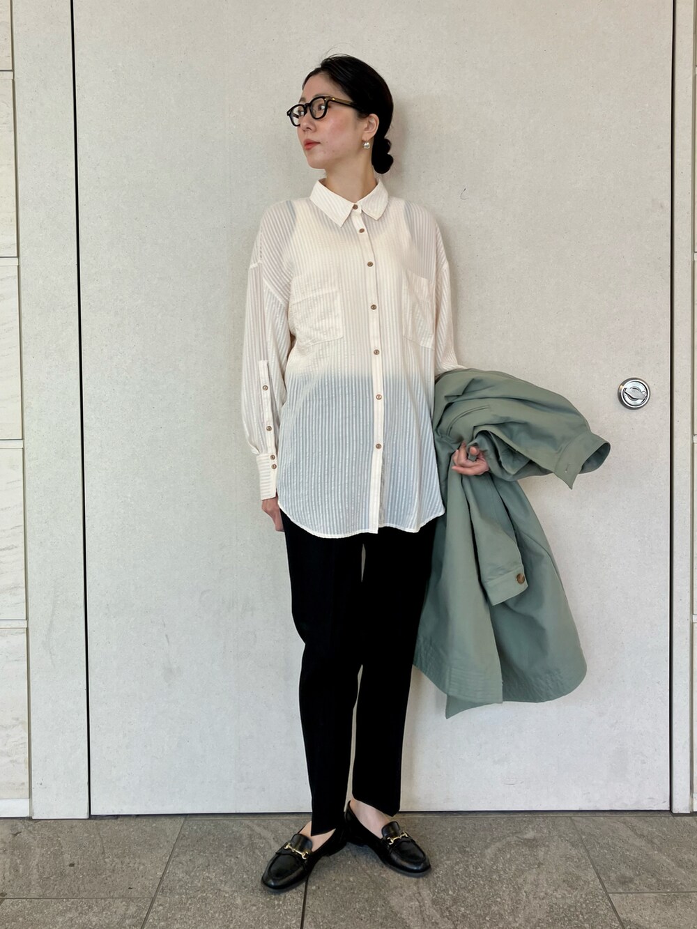 グリーン系のトレンチコート、ホワイト系のシャツ/ブラウス、ブラック系のその他パンツを着用したレディースの春コーディネートの5枚目の写真