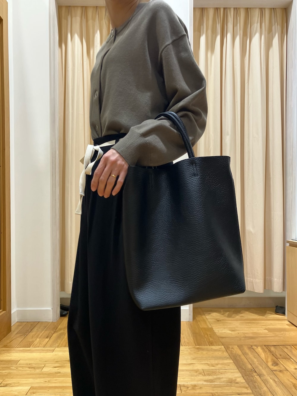 ブラウン系のカーディガン/ボレロ、ブラック系のその他パンツ、ブラック系のトートバッグを着用したレディースの冬コーディネートの5枚目の写真