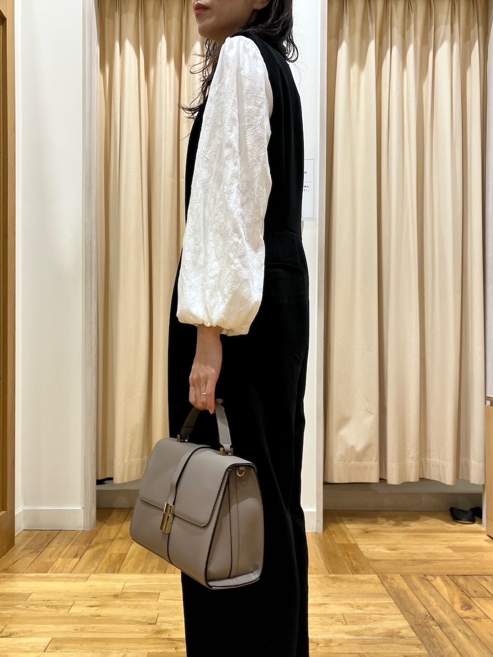 ブラック系のワンピース、ホワイト系のシャツ/ブラウス、グレー系のハンドバッグを着用したレディースの冬コーディネートの5枚目の写真