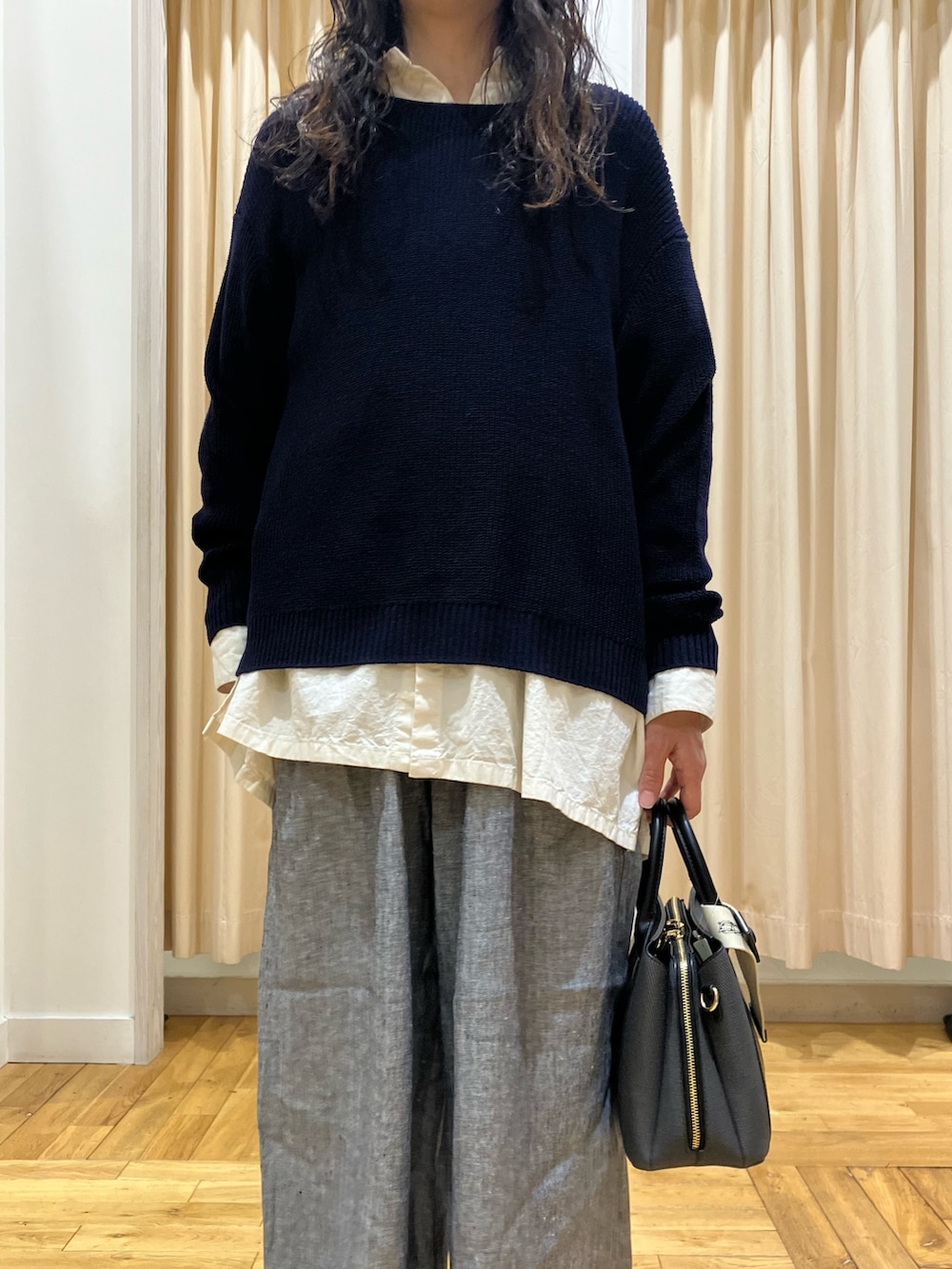 ブルー系のニット/セーター、ホワイト系のシャツ/ブラウス、グレー系のその他パンツを着用したレディースの春コーディネートの3枚目の写真