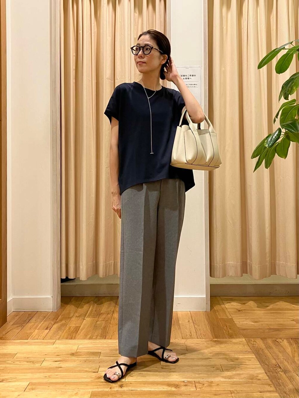 ホワイト系のトートバッグ、グレー系のその他パンツ、ブラック系のサンダルを着用したレディースの夏コーディネートの2枚目の写真