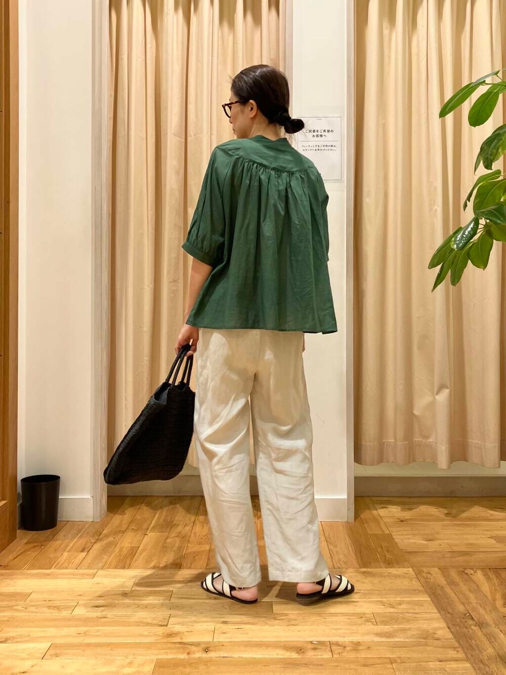 ブラック系のトートバッグ、ホワイト系のサンダル、ベージュ系のその他パンツを着用したレディースの夏コーディネートの4枚目の写真