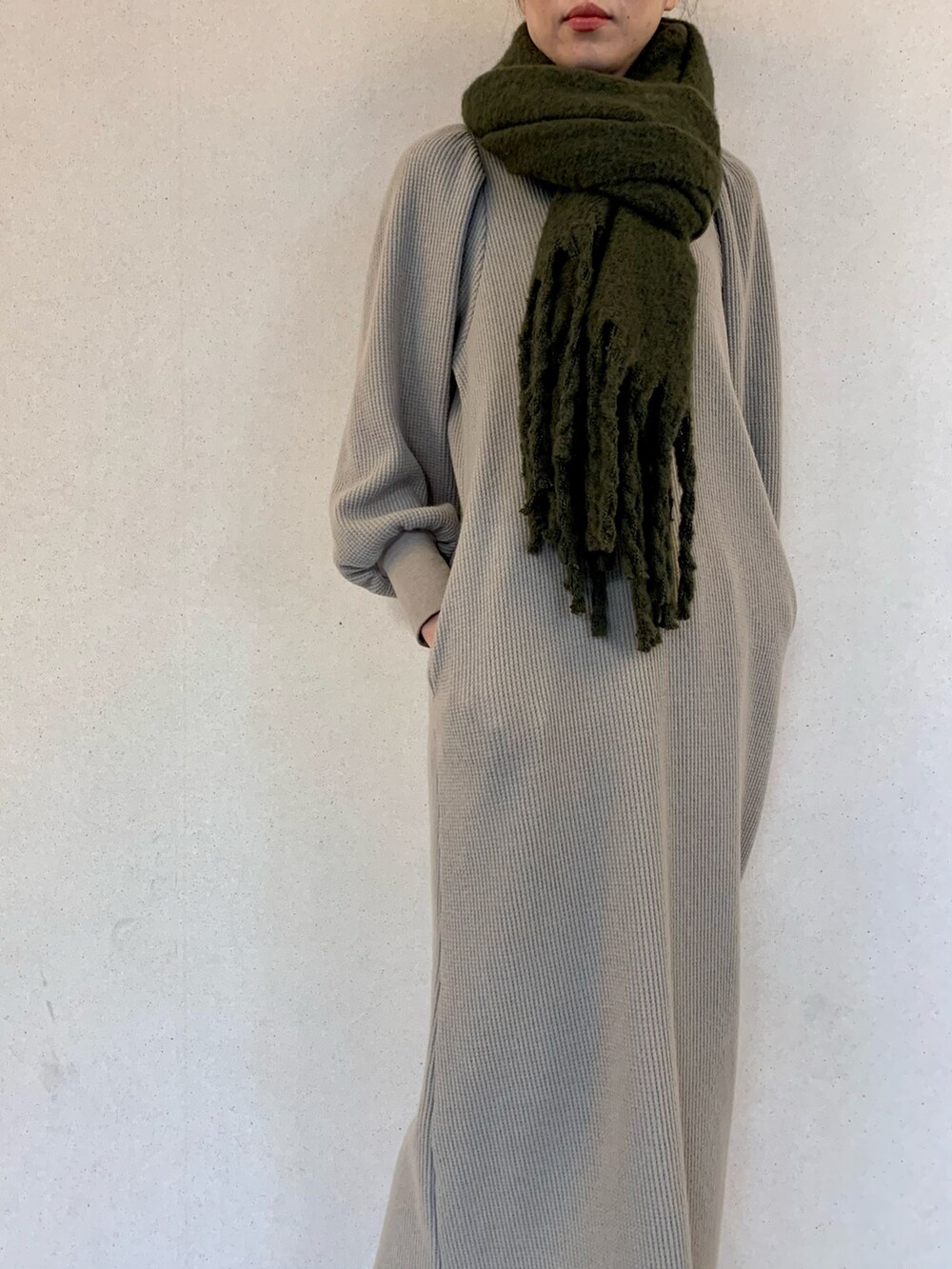 グレー系のワンピース、グリーン系のマフラーを着用したレディースの冬コーディネートの4枚目の写真