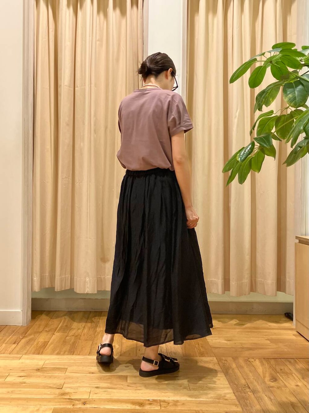 ブラック系のスカート、レッド系のTシャツ/カットソー、ブラック系のサンダルを着用したレディースの夏コーディネートの4枚目の写真