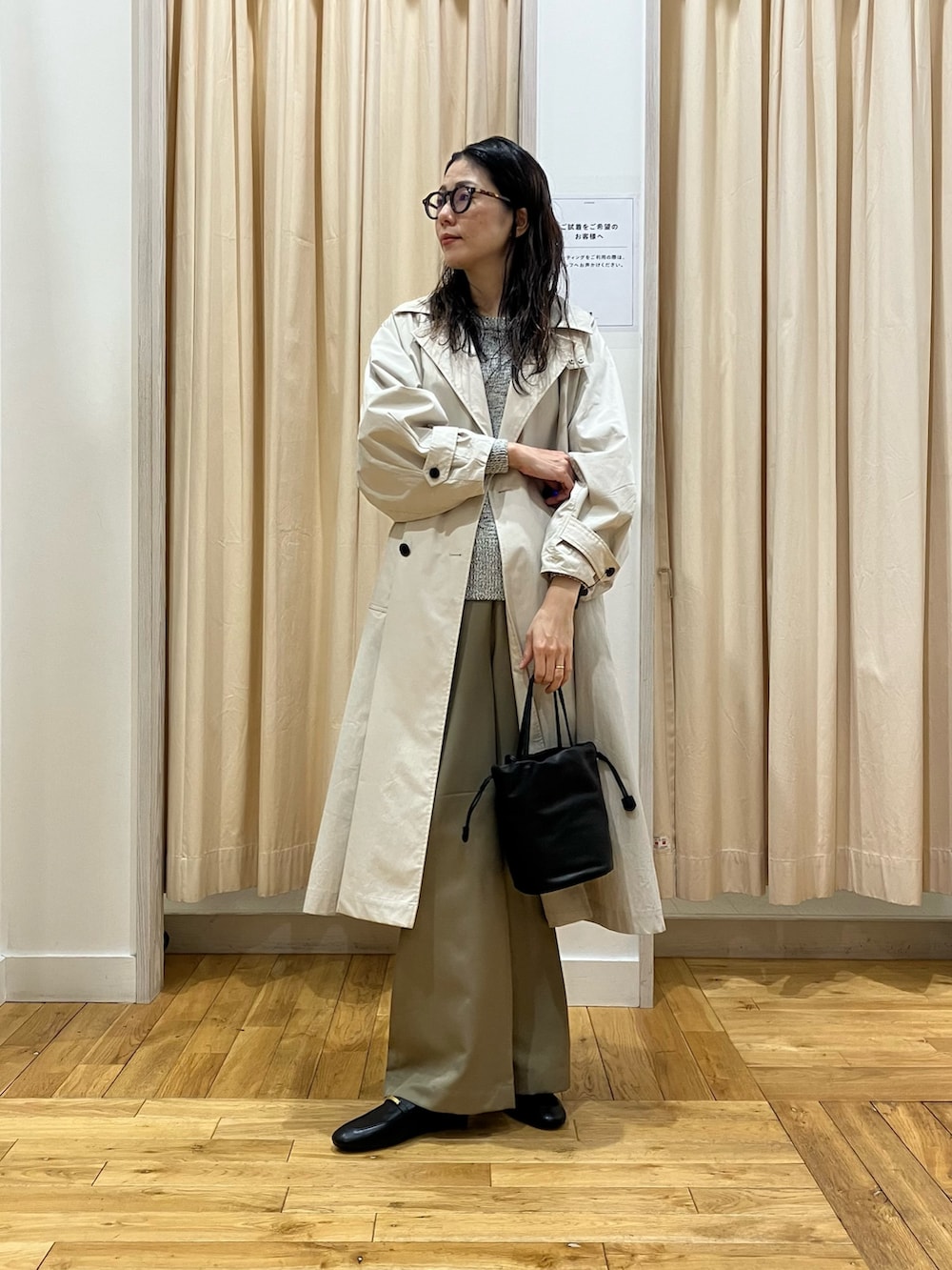 ベージュ系のその他パンツ、ベージュ系のトレンチコート、ブラック系のニット/セーターを着用したレディースの冬コーディネートの2枚目の写真