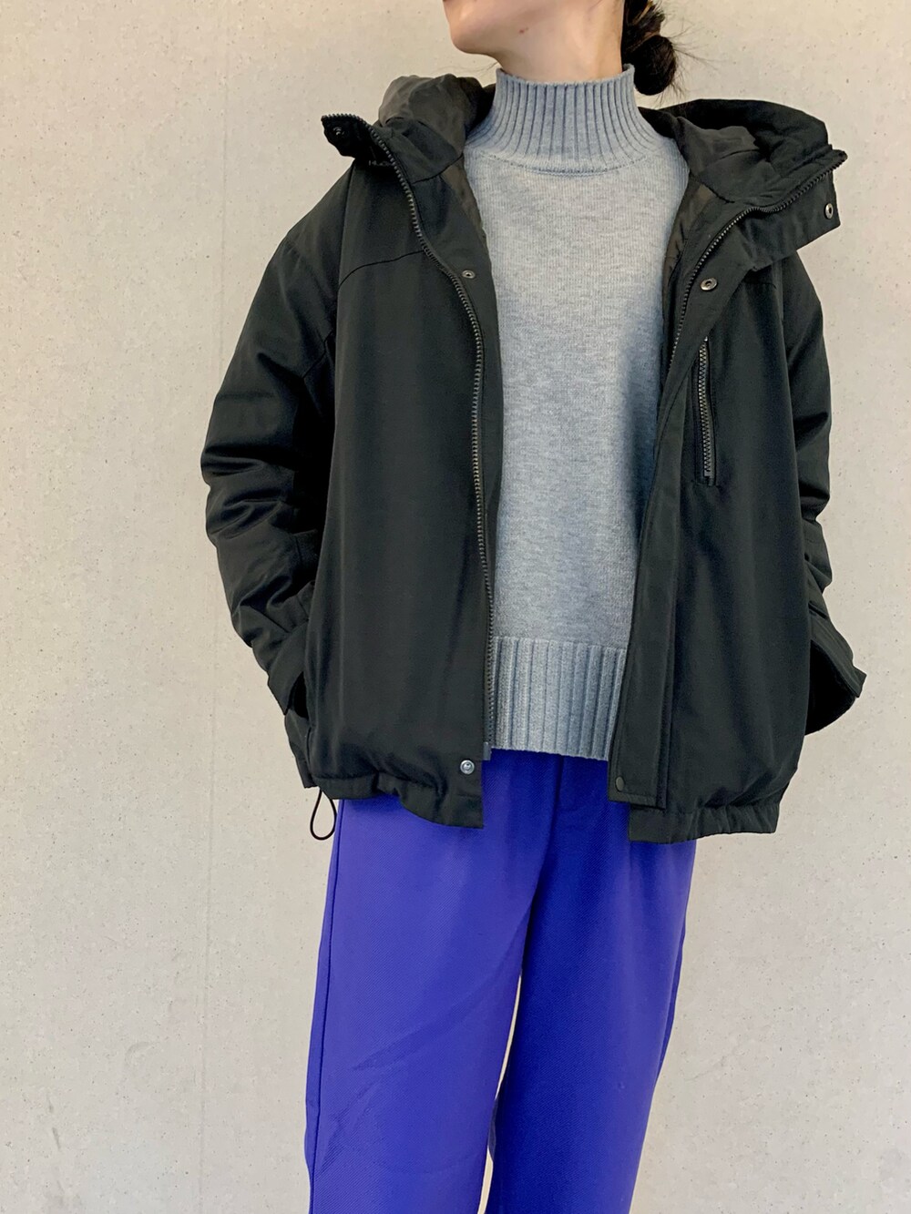 ブラック系のダウンジャケット/コート、グレー系のニット/セーター、ブルー系のその他パンツを着用したレディースの冬コーディネートの4枚目の写真