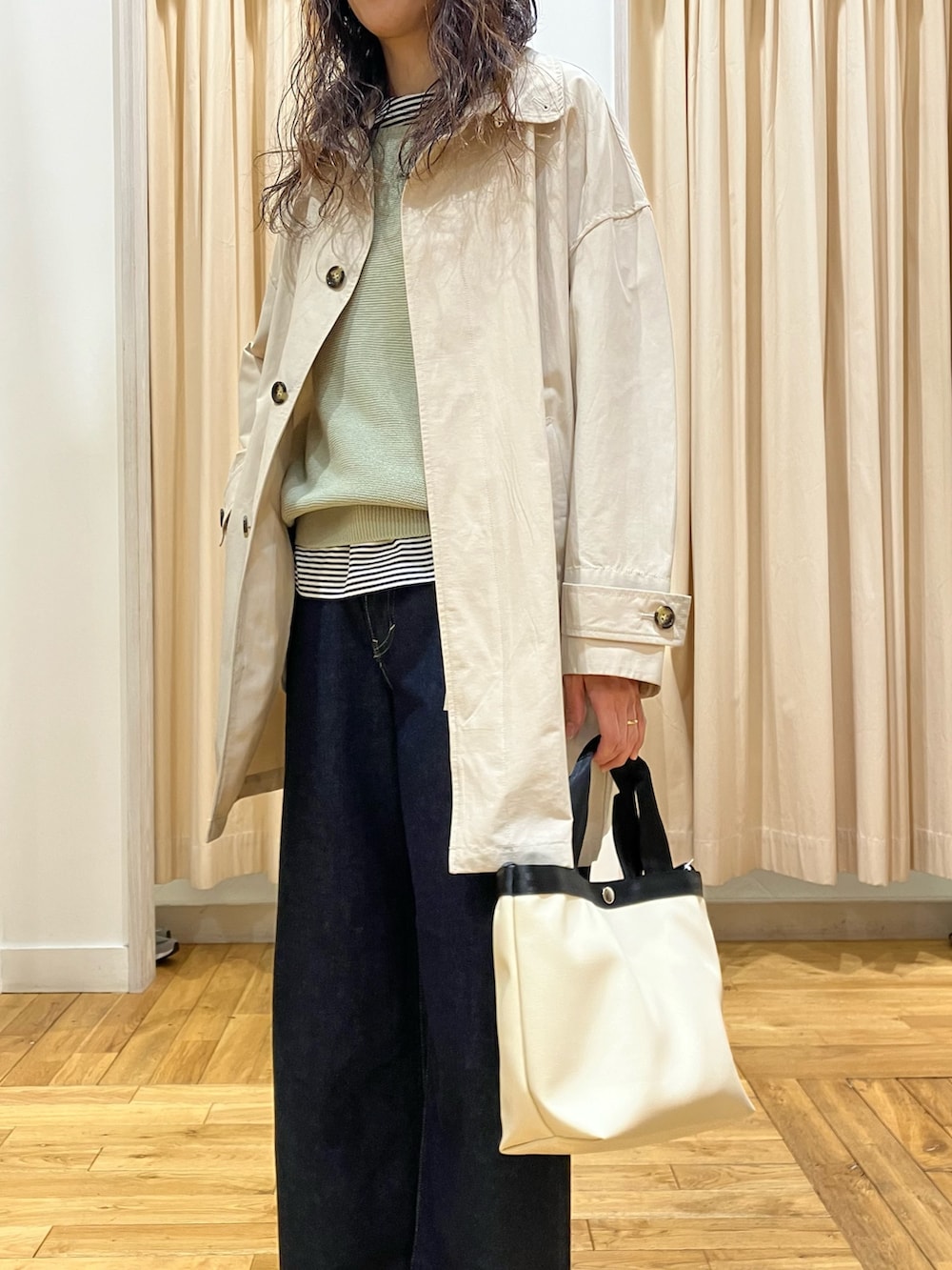 グリーン系のニット/セーター、ベージュ系のステンカラーコート、ブラック系のその他シューズを着用したレディースの春コーディネートの4枚目の写真