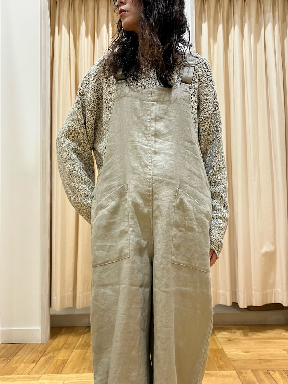 ベージュ系のニット/セーター、ブラック系のその他シューズ、グレー系のサロペット/オーバーオールを着用したレディースの冬コーディネートの5枚目の写真