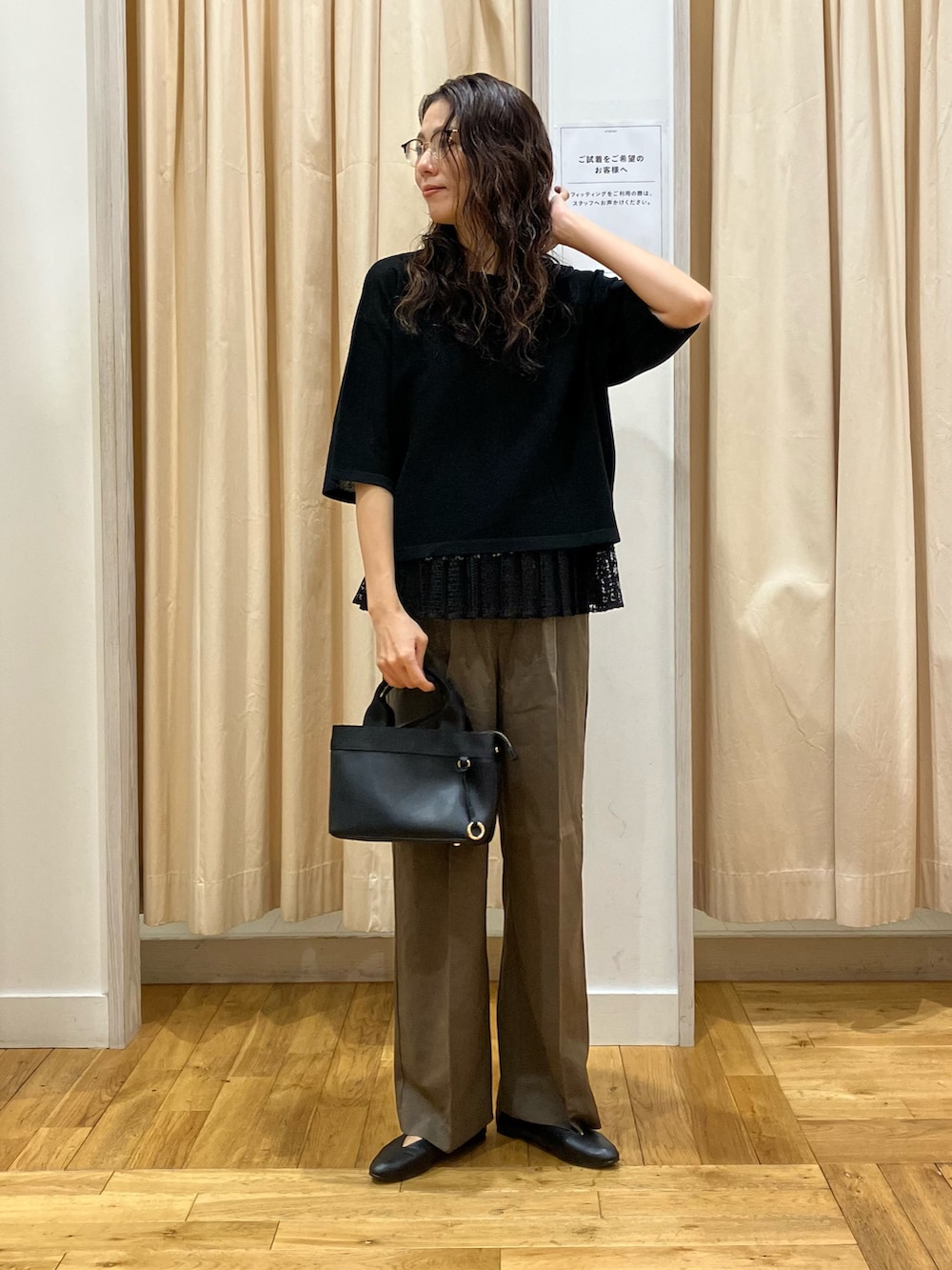 ブラック系のニット/セーター、ブラック系のパンプス、グリーン系のその他パンツを着用したレディースの秋コーディネートの2枚目の写真