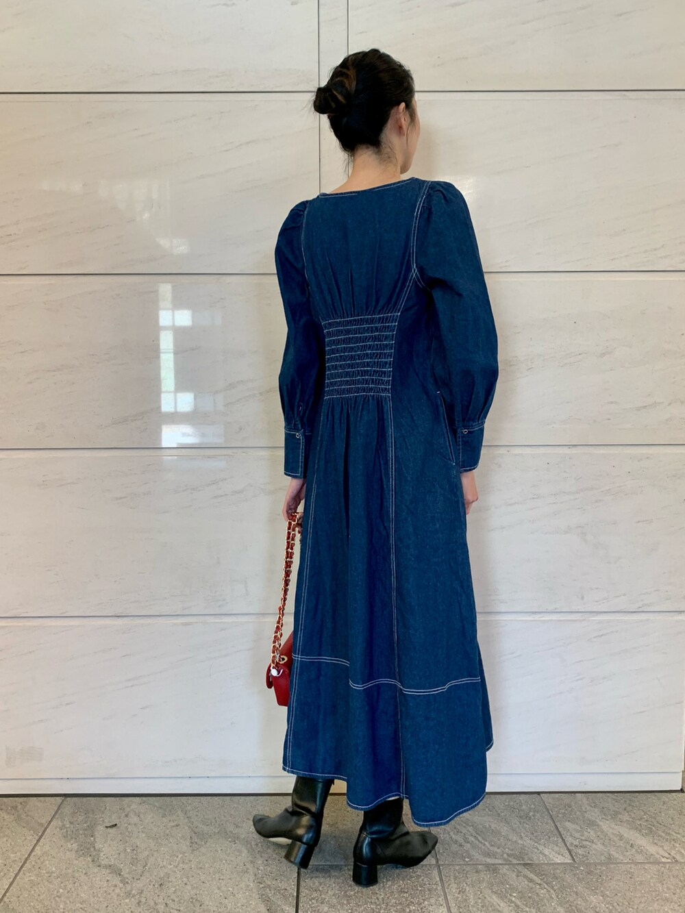 ブルー系のワンピース、レッド系のショルダーバッグを着用したレディースの冬コーディネートの4枚目の写真