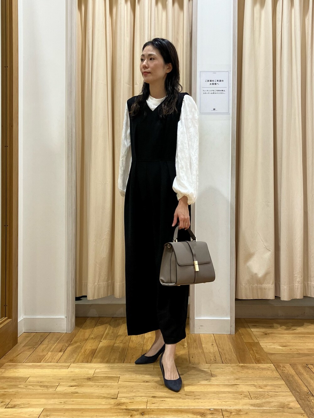 ブラック系のワンピース、ホワイト系のシャツ/ブラウス、グレー系のハンドバッグを着用したレディースの冬コーディネートの2枚目の写真