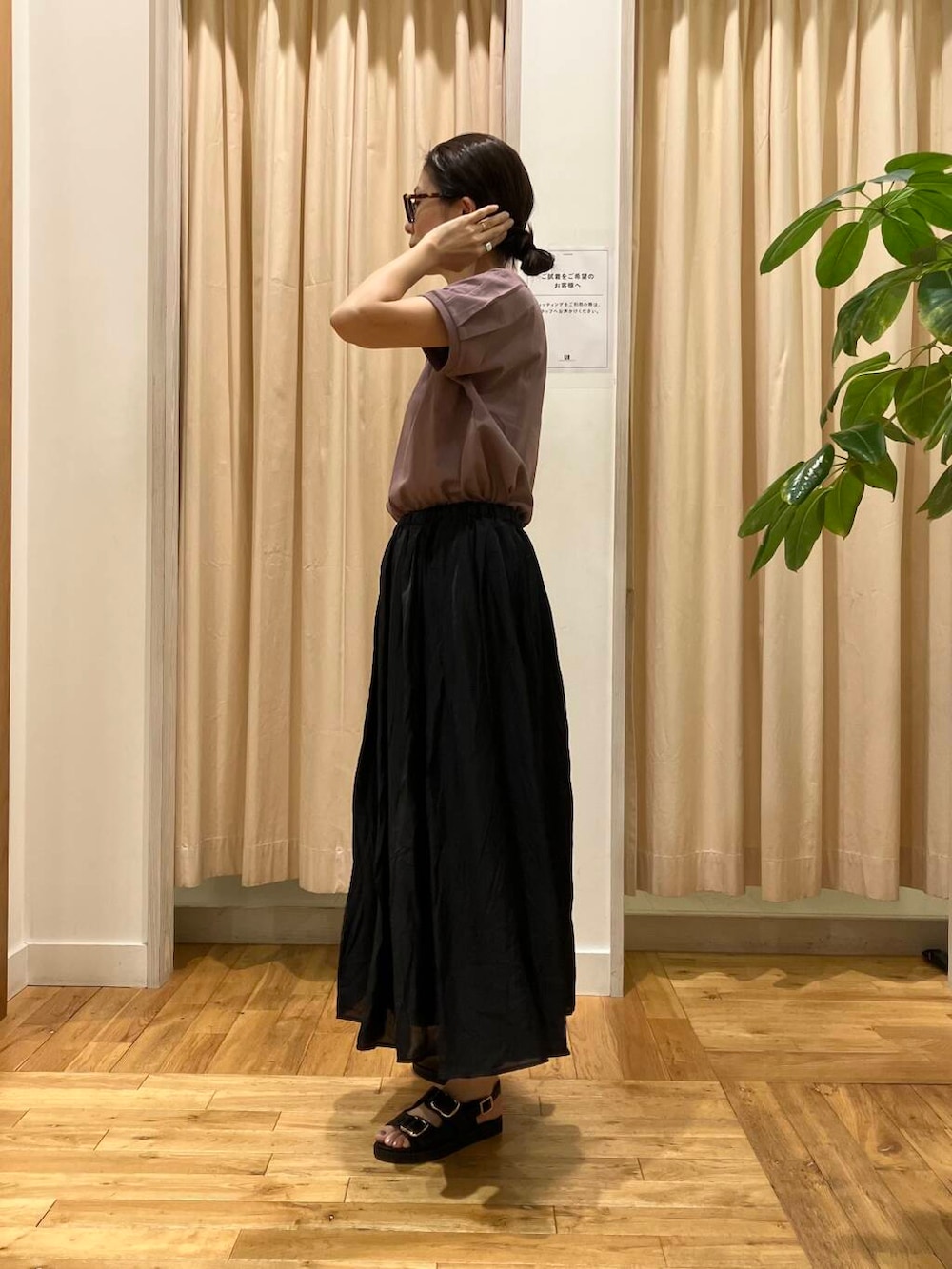 ブラック系のスカート、レッド系のTシャツ/カットソー、ブラック系のサンダルを着用したレディースの夏コーディネートの3枚目の写真