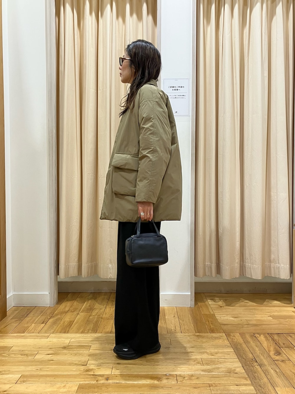 ブラック系のその他パンツ、ブラック系のボストンバッグ、ホワイト系のシャツ/ブラウスを着用したレディースの冬コーディネートの3枚目の写真