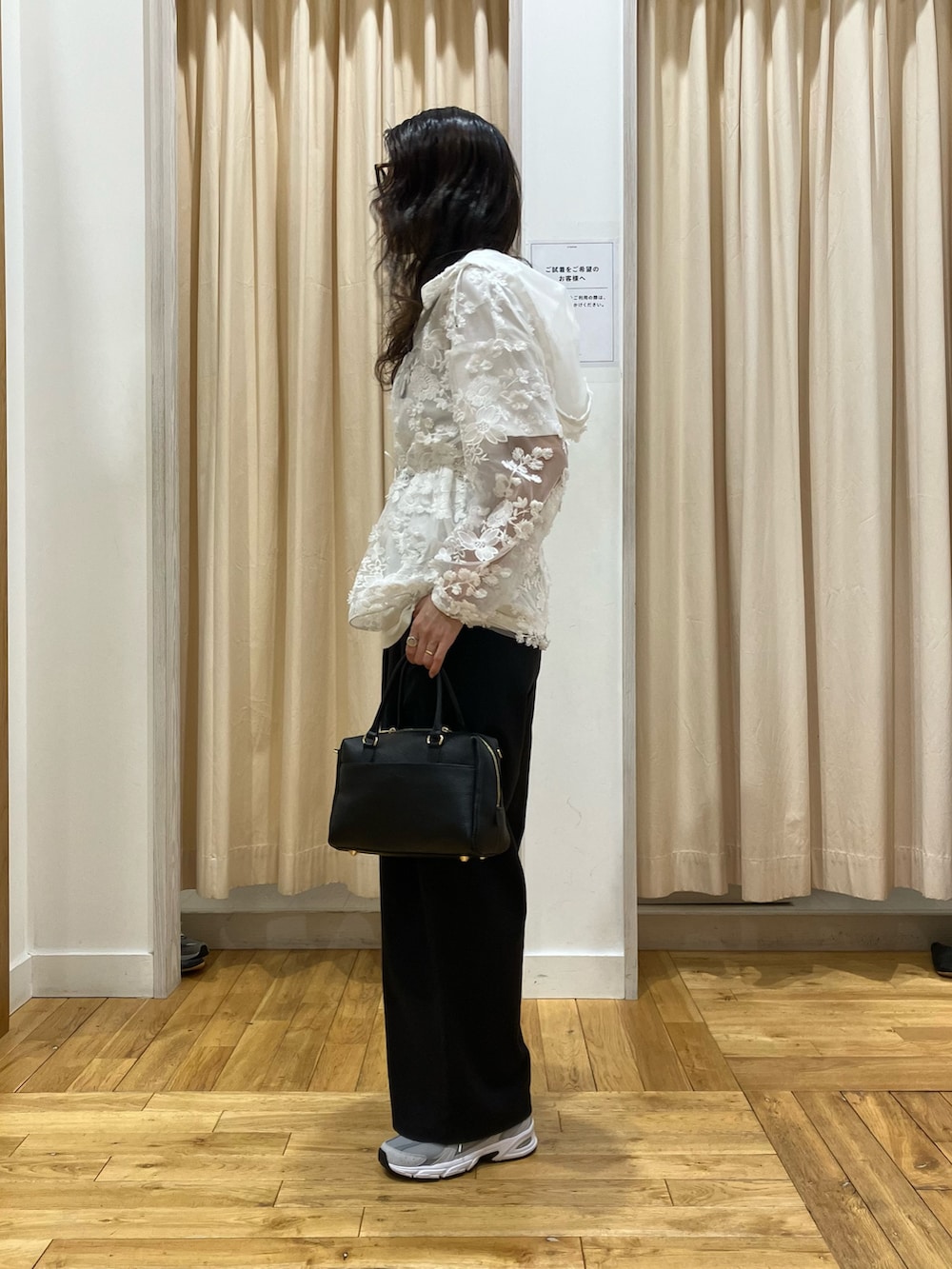 ホワイト系のパーカー、グレー系のスニーカー、ブラック系のその他パンツを着用したレディースの春コーディネートの3枚目の写真