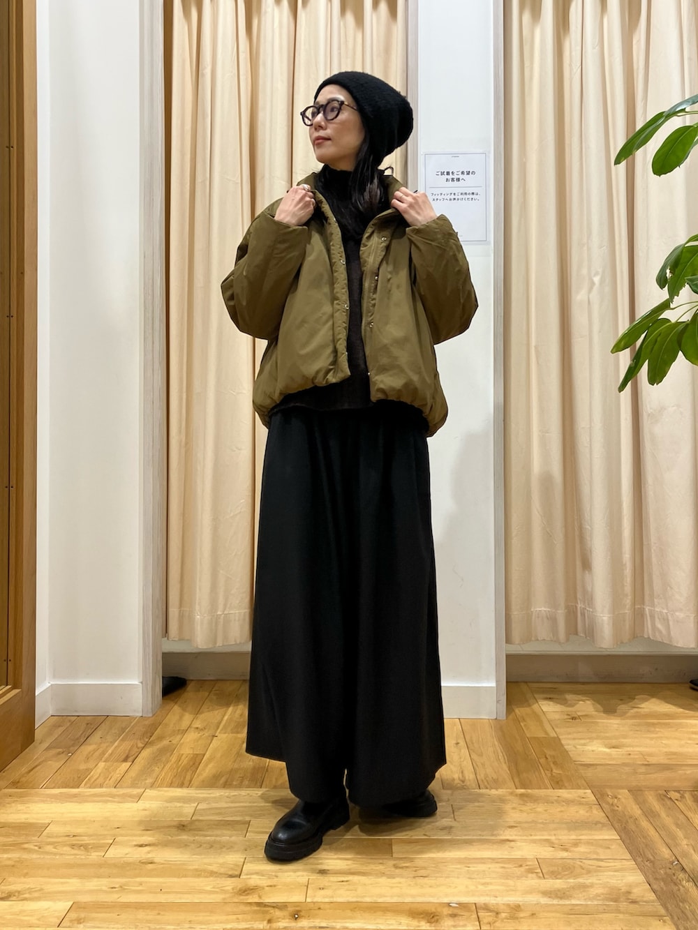 ブラウン系のニット/セーター、グリーン系のブルゾン、ブラック系のその他パンツを着用したレディースの冬コーディネートの2枚目の写真