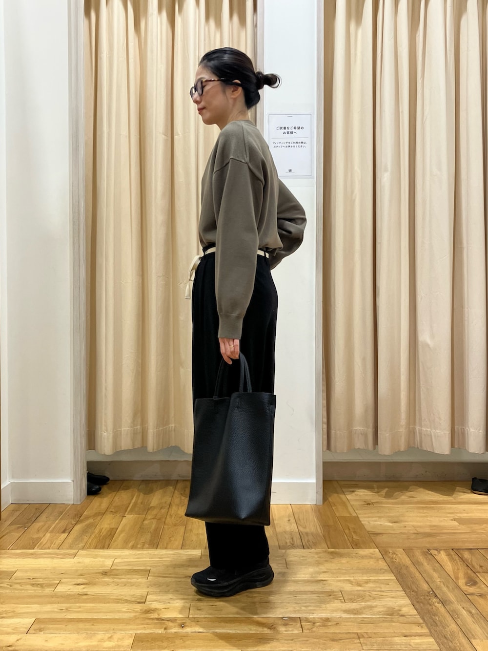 ブラウン系のカーディガン/ボレロ、ブラック系のその他パンツ、ブラック系のトートバッグを着用したレディースの冬コーディネートの2枚目の写真