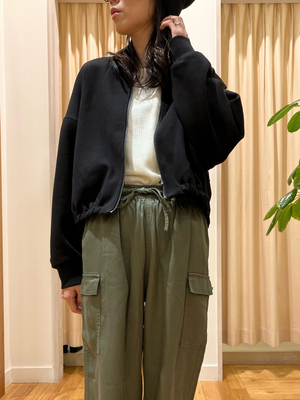 ホワイト系のTシャツ/カットソー、ブラック系のカーディガン/ボレロ、グリーン系のその他パンツを着用したレディースの秋コーディネートの5枚目の写真